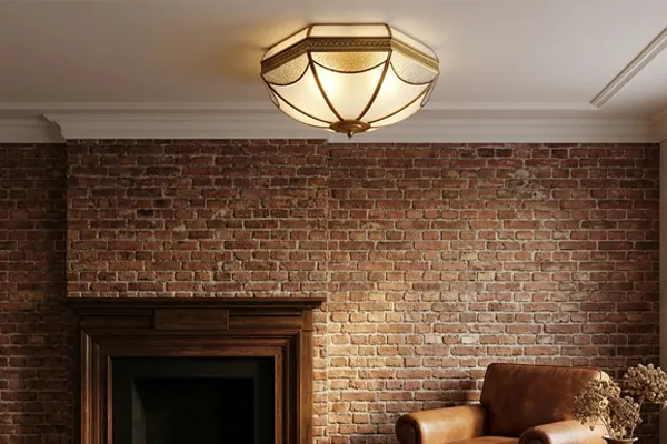 Brass flush mount ceiling light above brick fireplace wall